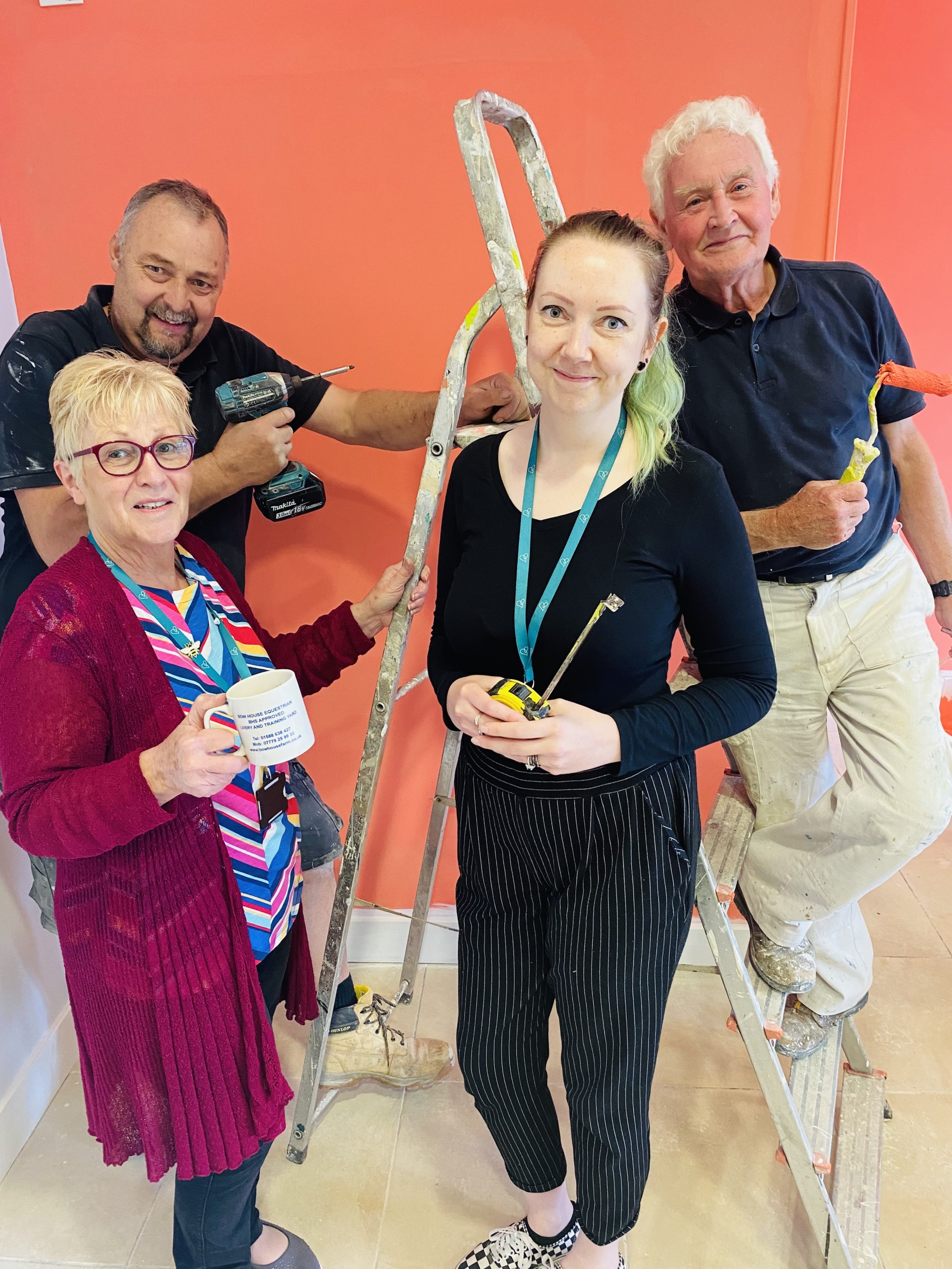 Lucy Anderson-Woods, Retail Strategy Support Manager and Helen Evans-Thomas incoming shop manager along with two of the builders and decorators who have been busy turning the former beauty salon into the new shop.