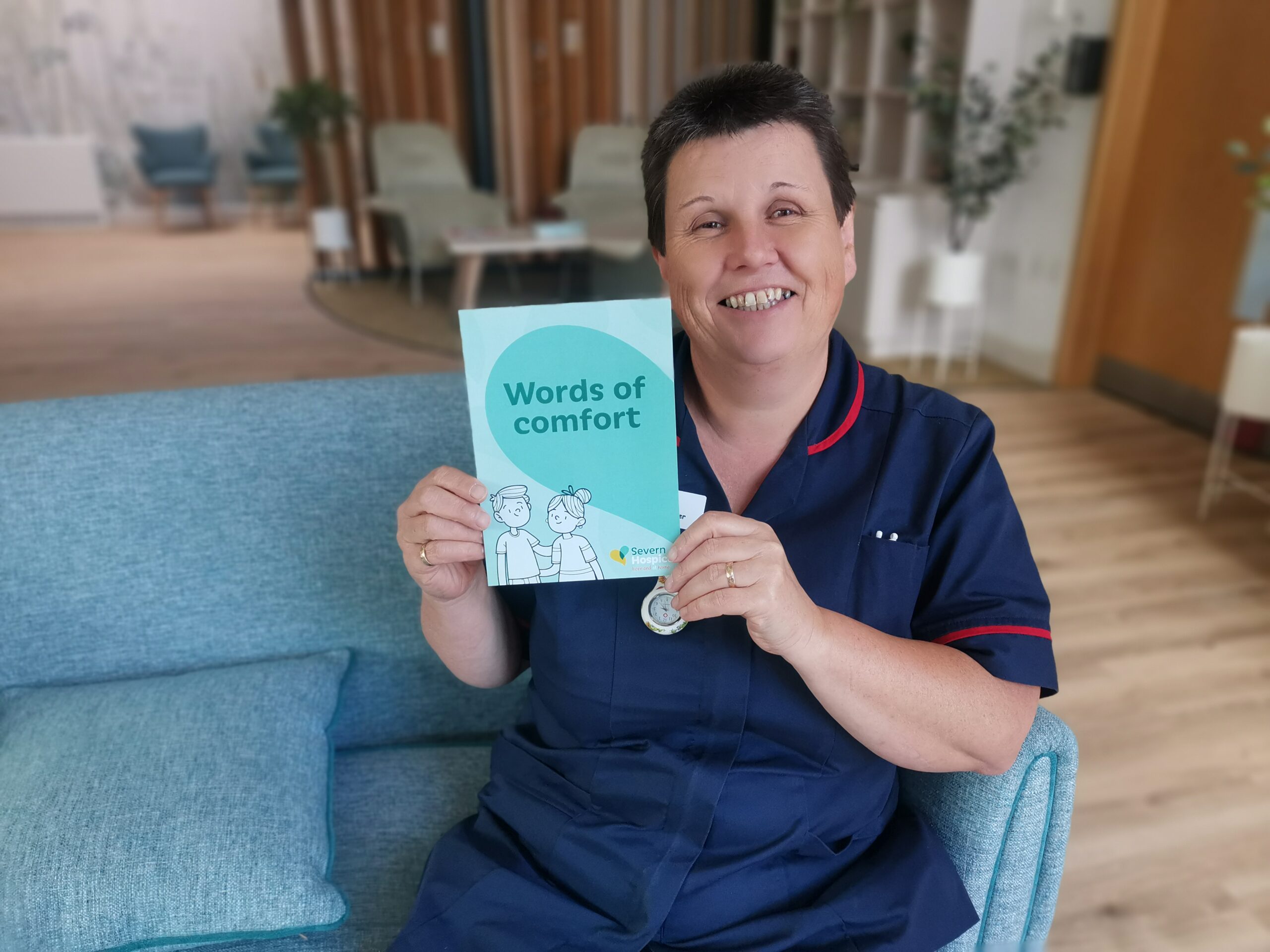 Mandy, Ward Manager at Severn Hospice holds a copy of the 'Words of comfort' booklet in the communal area on the ward.