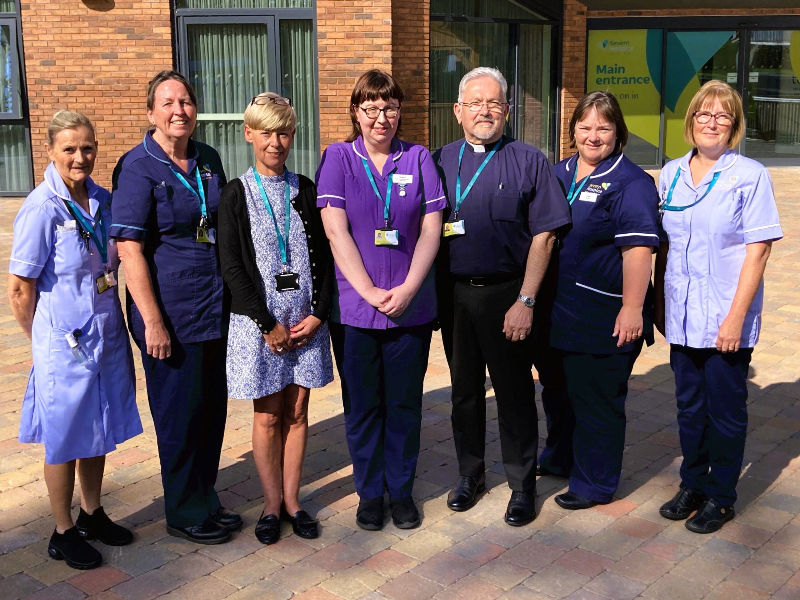 Group of nurses, healthcare assistants, Chaplain, social worker and complementary therapist standing outside Severn Hospice