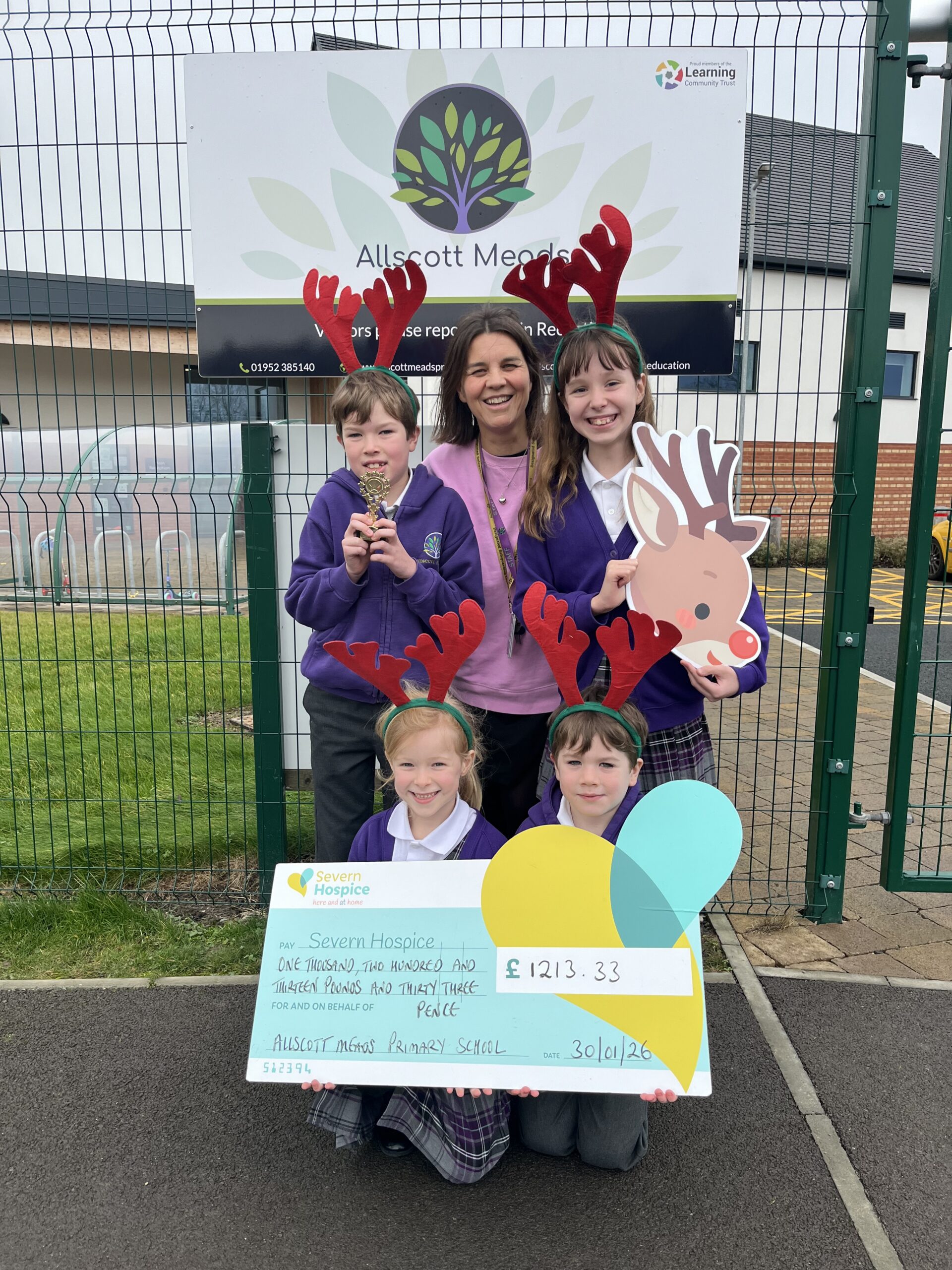 Allscott Meads Primary and Nursery School pupils and headteacher Kirsty Parkinson pose with Severn Hospice branded cheque showing their fundraising amount of £1213.33.