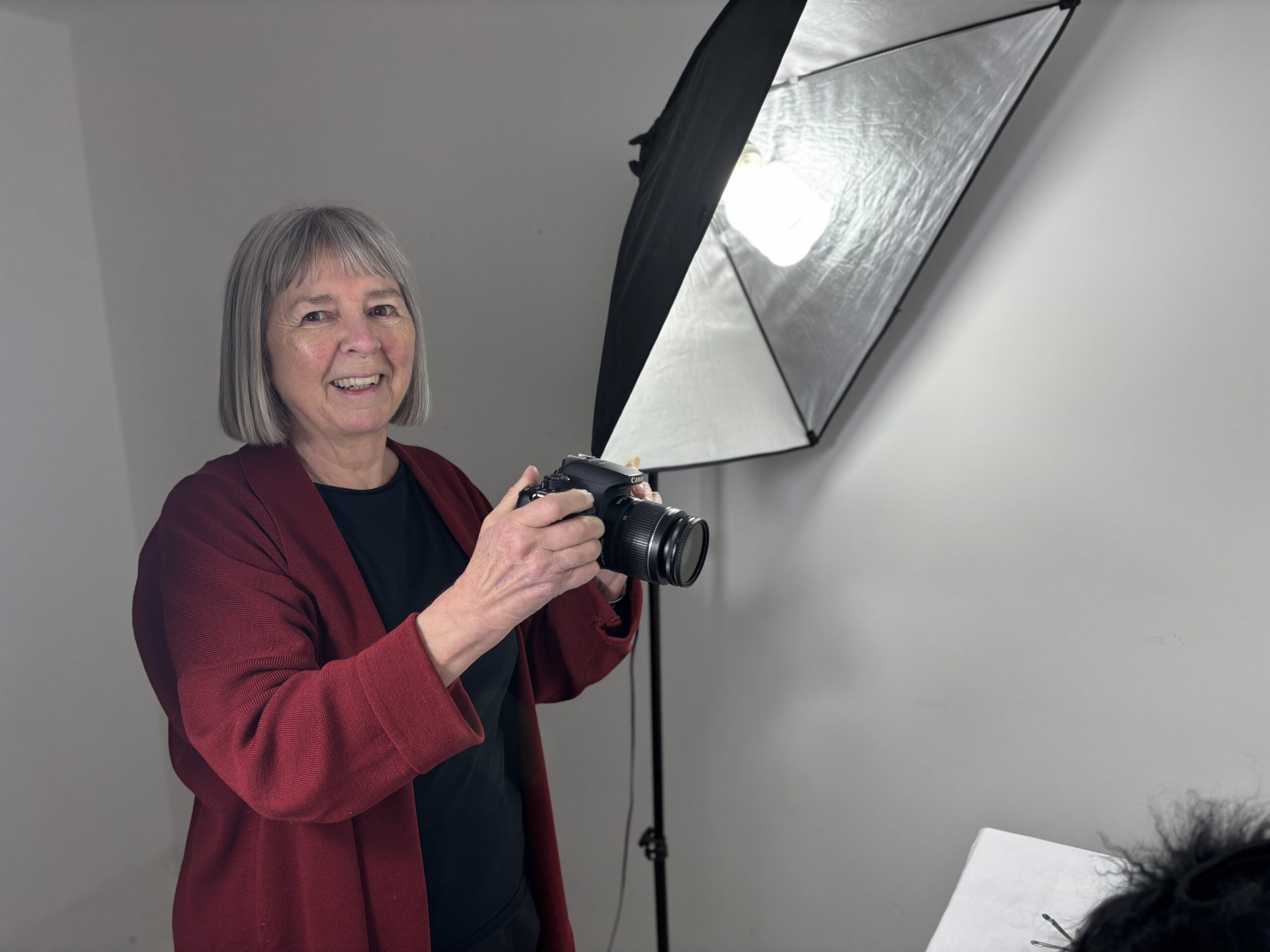 Person standing with digital camera in hand