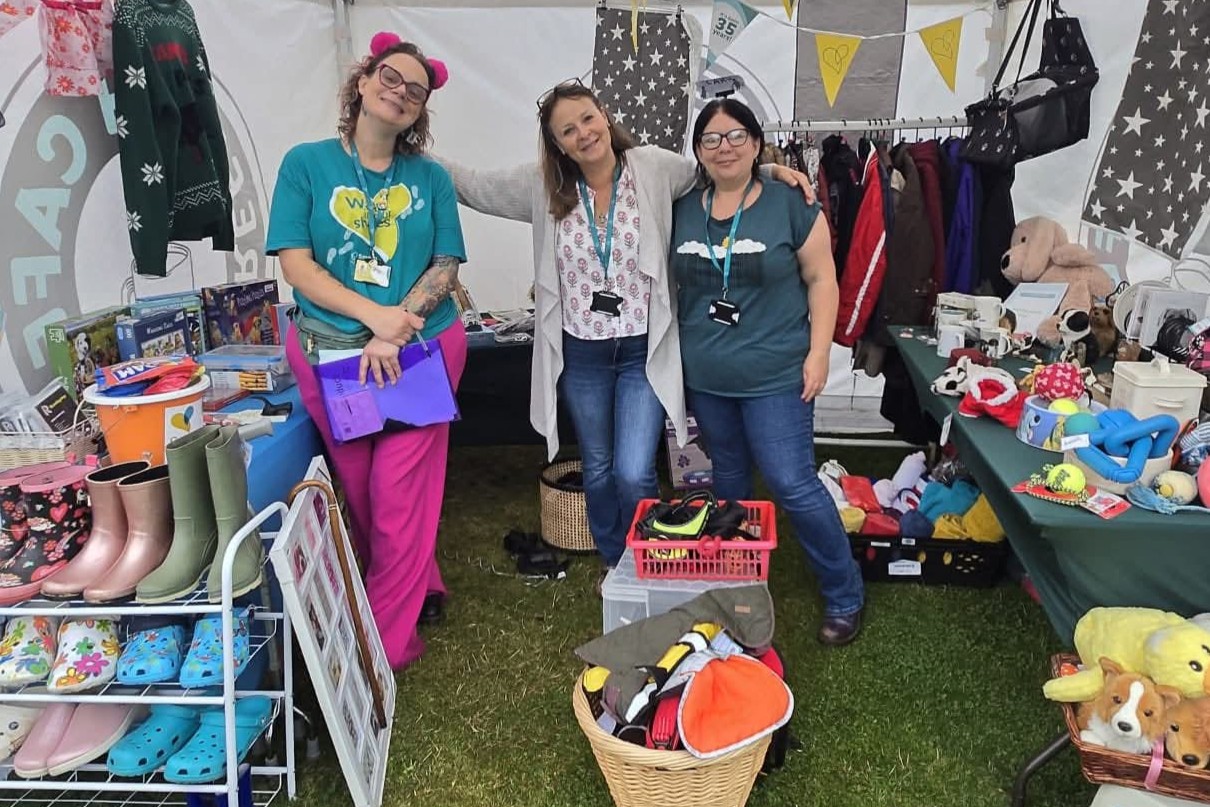 Three people standing in a pop-up shop full of clothes, toys and accessories