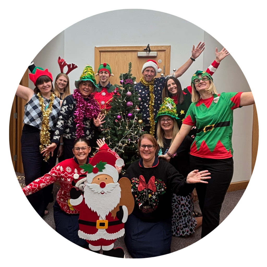 A group of people wearing Christmas jumpers, elf outfits and lots of tinsel